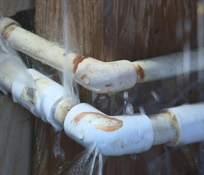 corner pipes located around a wood plank with water spraying out in multiple places